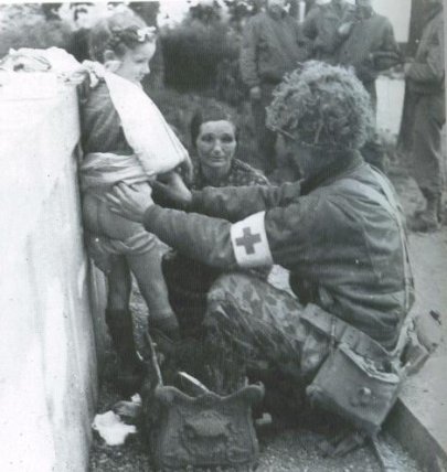 Un soldat de la 2nd armored division soigne une jeune Normande